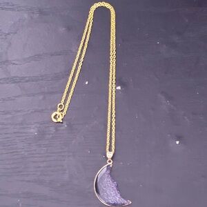 celestial-themed pendant necklace featuring a crescent moon charm with a dark